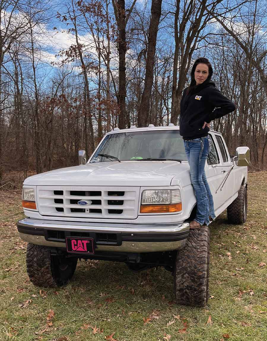 Taylor Teets standing on the wheel of her F350
