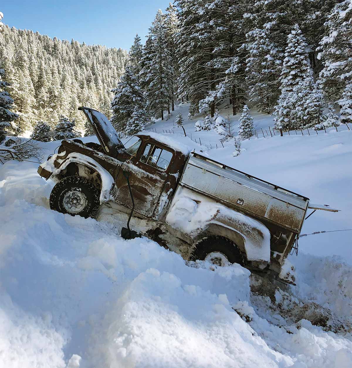 Power Wagon driving up snowy hill with hood open