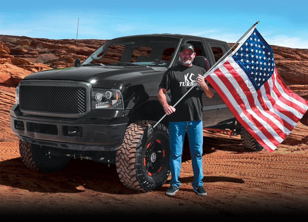 man with American flag in front of his truck