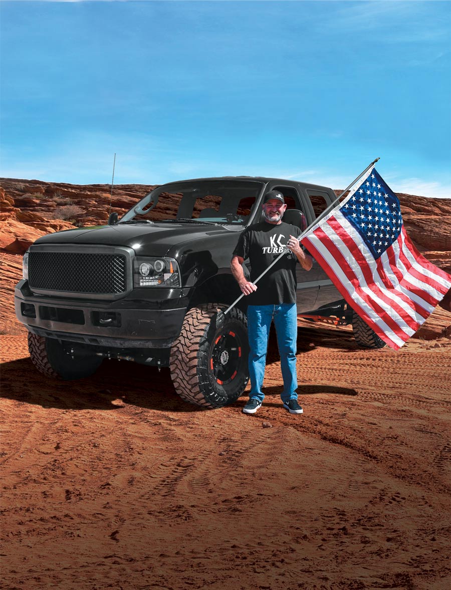 man with American flag in front of his truck
