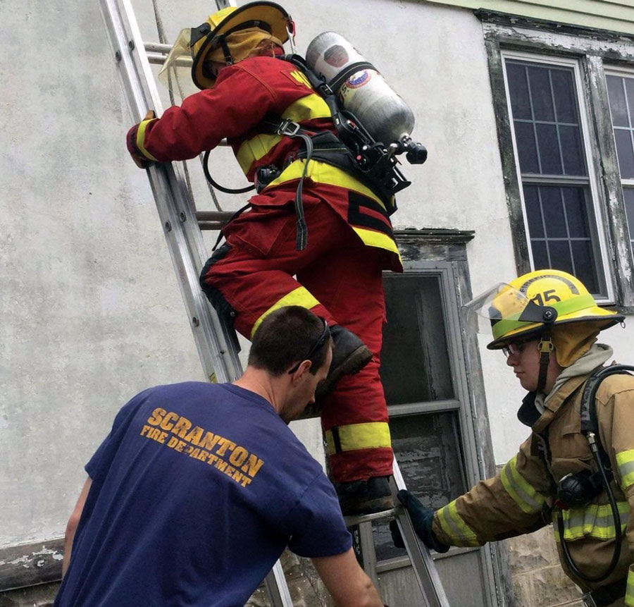 Firefighter climbing ladder