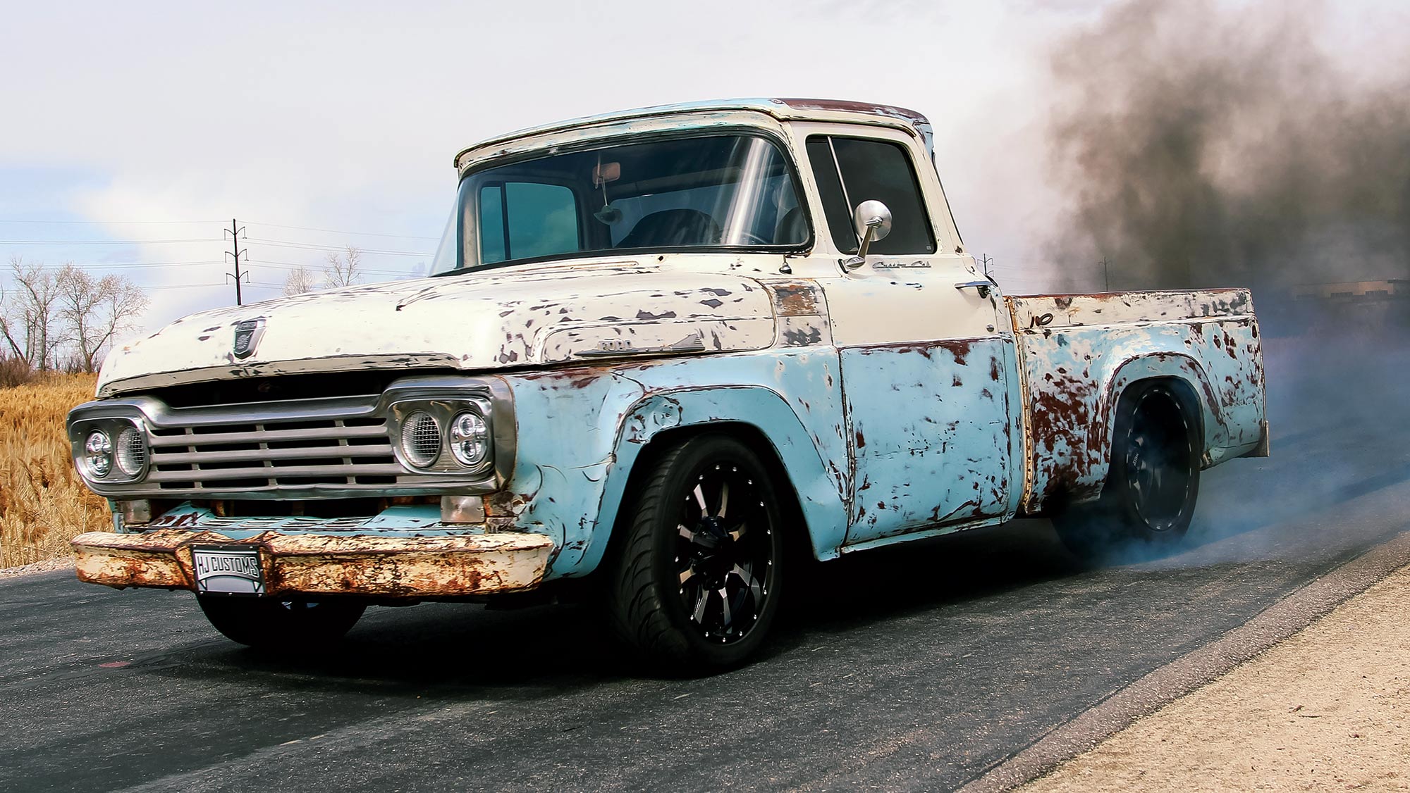 '58 Ford truck side profile of it driving on a road