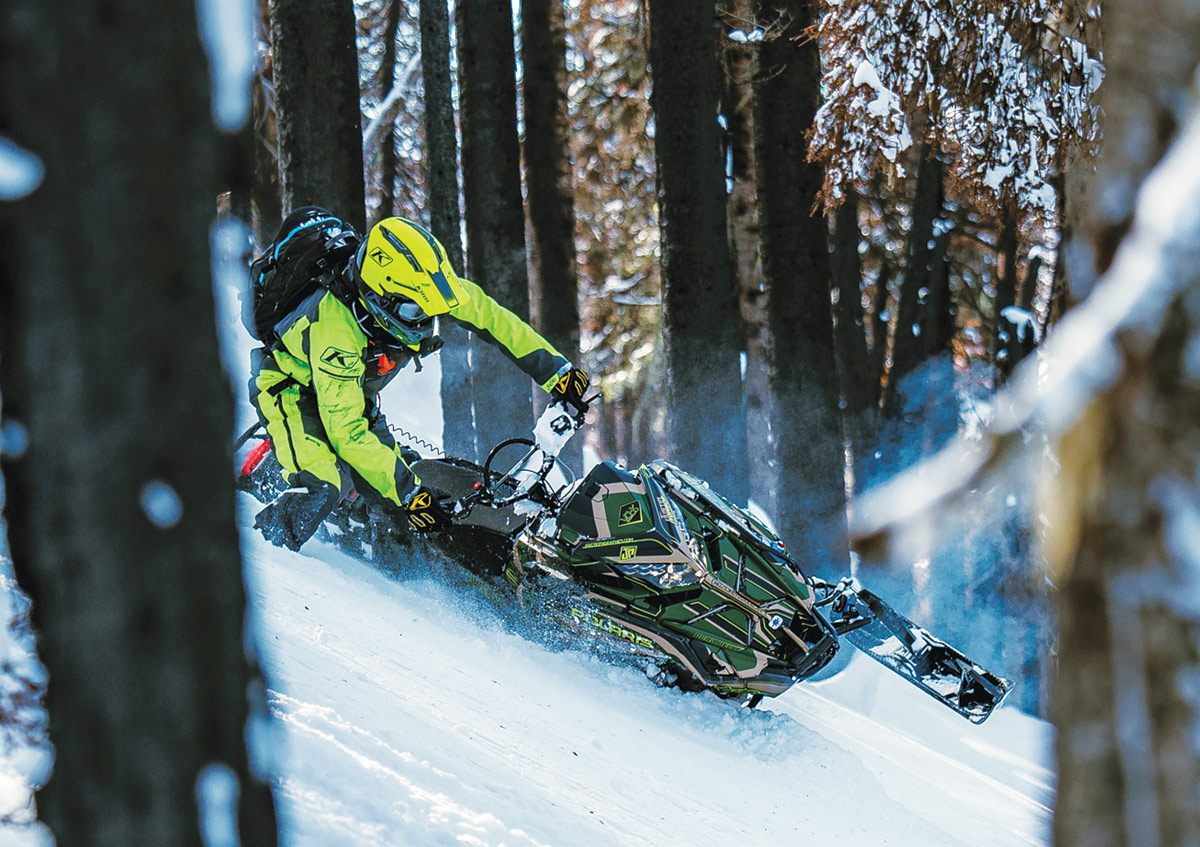 man on snowmobile going down mountain