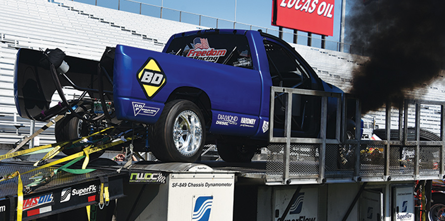 blue truck on trailer blowing smoke