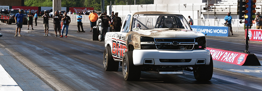 white and muddy truck in a drag race