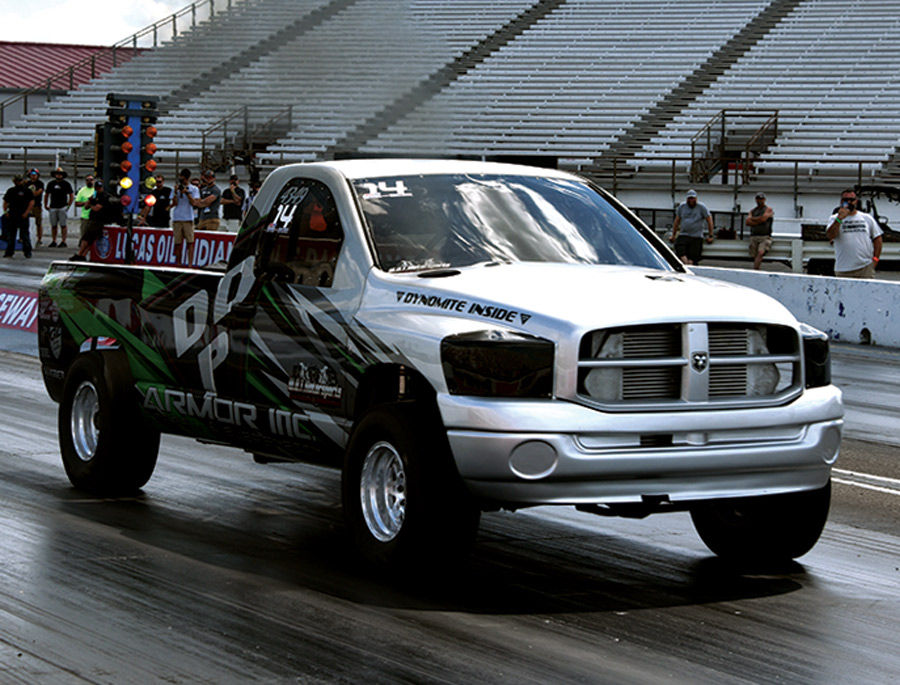 white truck with green and black decals in a drag race