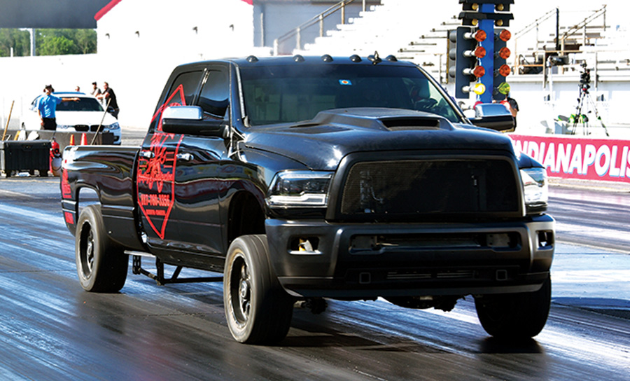 black truck with red decals in a drag race