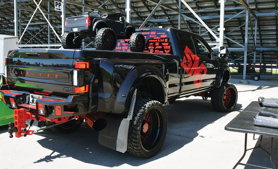 black truck with red decals and a kids truck in the bed