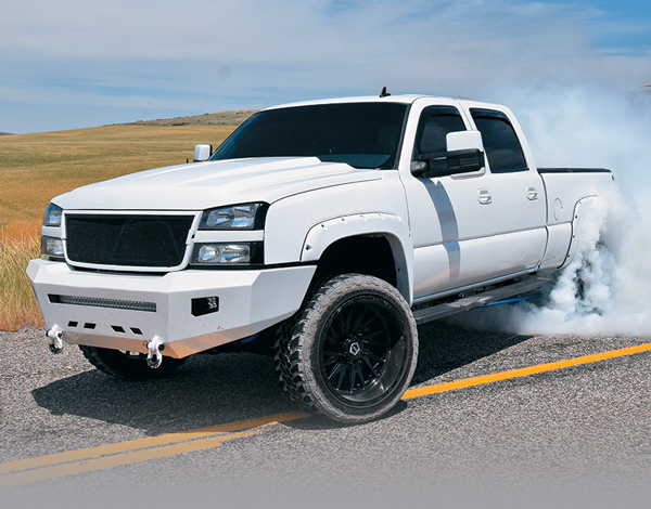 white truck creating smoke with tires