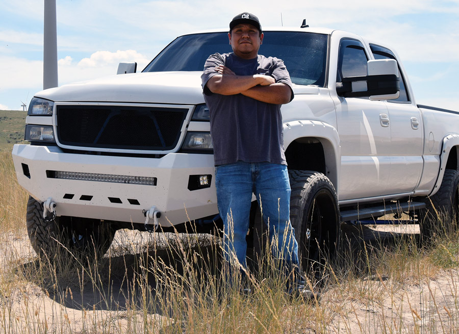 man standing in front of his white truck