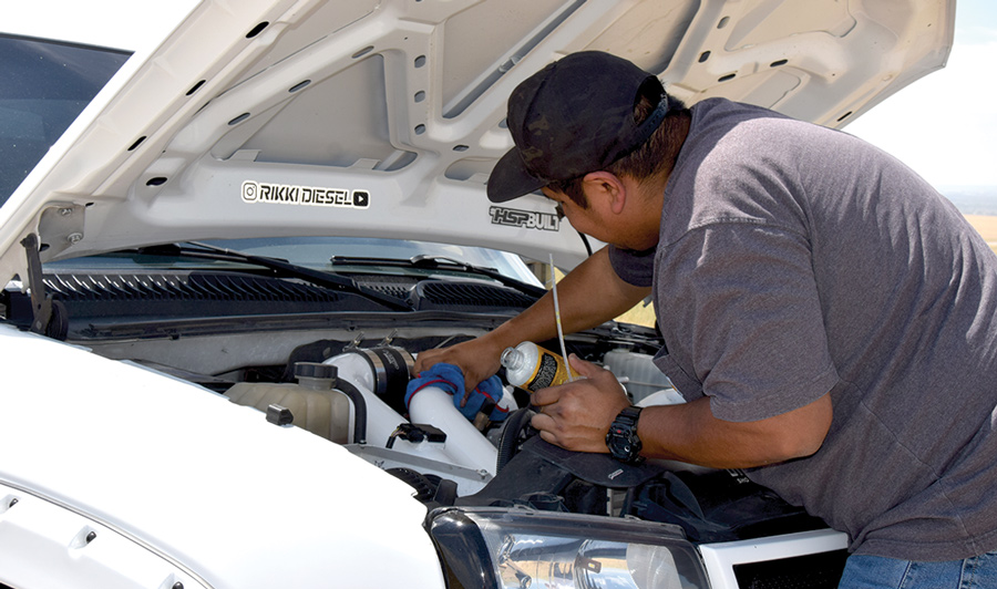 man working under the hood of his truck