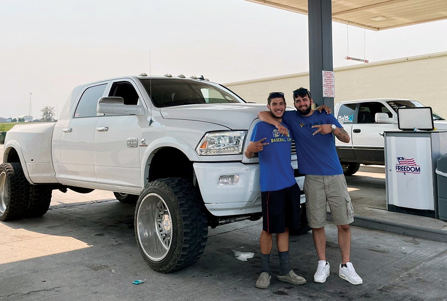 two men in front of RAM truck at gas station