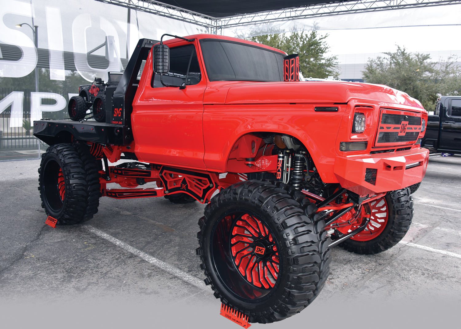 red lifted truck with a quad on the back