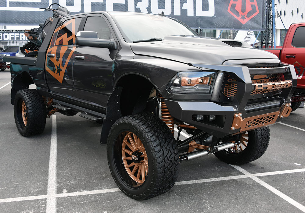 black truck with bronze trim and a matching snow mobile on the back